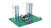 Angled view of the capacitive touch liquid level indicator reference design with two transparent tanks, connecting tubes, sensors, and a CPU board and control board.