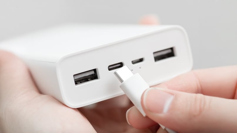 Hand inserting usb type-c connector into powerbank