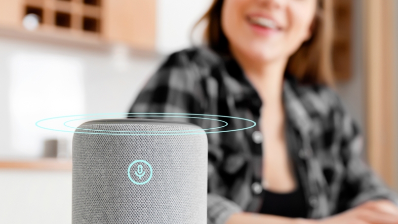 Person talking with smart speaker that uses ai voice recognition