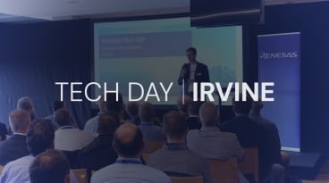 Renesas' Tech Day session featuring a speaker addressing an audience with a slideshow in the background.