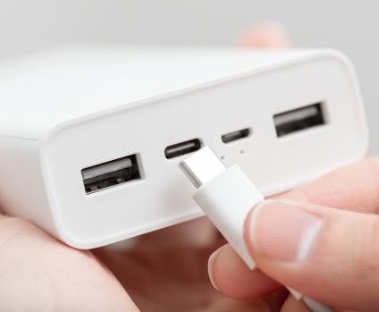 Hand plugging a usb type-c cable into a powerbank