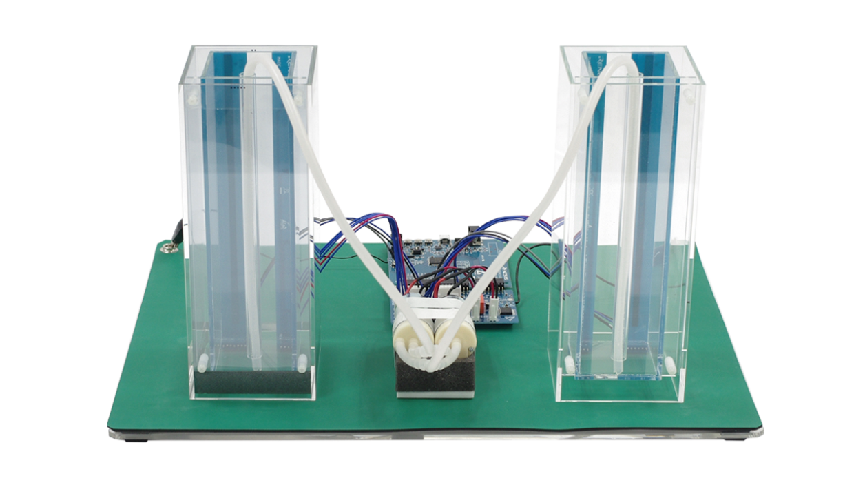 Back view of the capacitive touch liquid level indicator reference design with two transparent tanks, connecting tubes, sensors, and a CPU board and control board.