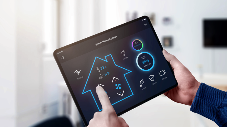 Person's hand changing temperature on a tablet's smart home control app.