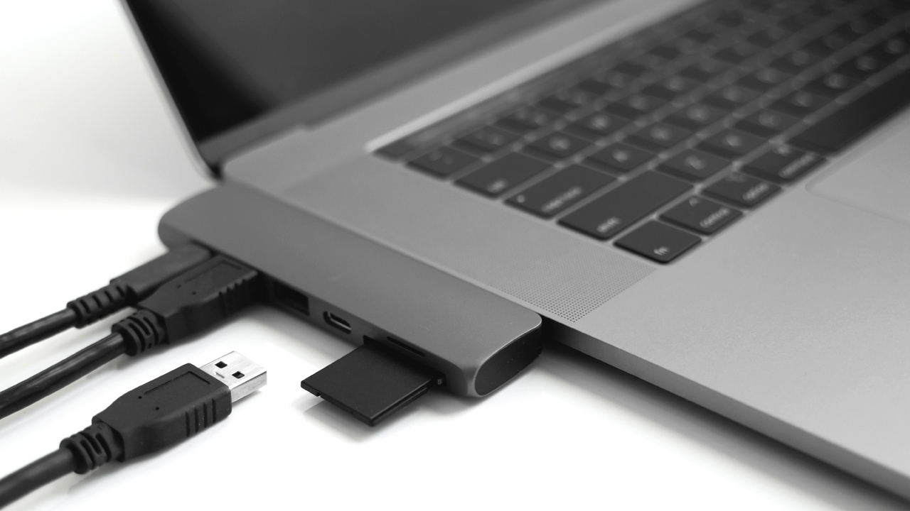 USB Type-C Adapter Laptop with USB Type-C adapter with plugged USB cables and SD card.
